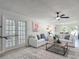 Open living area with neutral decor, ceiling fan, and view into the dining area and outdoor space at 28432 Tammi Dr, Tavares, FL 32778