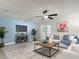 Bright living room featuring light blue accent wall, ceiling fan, and stylish decor with large patterned rug at 28432 Tammi Dr, Tavares, FL 32778