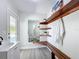 Well-organized mudroom featuring a wood bench, mirror and corner shelving and storage at 28432 Tammi Dr, Tavares, FL 32778