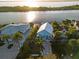 Stunning aerial view of waterfront home surrounded by lush greenery and featuring a dock at 3110 John Anderson Dr, Ormond Beach, FL 32176