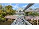 A dock leading to a lovely home with beautiful landscaping and a pool at 3110 John Anderson Dr, Ormond Beach, FL 32176