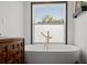 Bright bathroom featuring a soaking tub, modern fixtures, and natural light from large window at 3110 John Anderson Dr, Ormond Beach, FL 32176