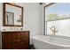 Bright bathroom with a vanity cabinet, modern fixtures, soaking tub and natural light at 3110 John Anderson Dr, Ormond Beach, FL 32176