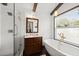 Bathroom with a vanity cabinet, soaking tub, glass enclosed shower and natural light at 3110 John Anderson Dr, Ormond Beach, FL 32176