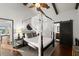 Bedroom featuring high ceilings, barn door, hardwood floors, and stylish decor at 3110 John Anderson Dr, Ormond Beach, FL 32176
