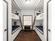 Charming hallway showcasing unique built-in bunk beds with ladders and personal storage at 3110 John Anderson Dr, Ormond Beach, FL 32176