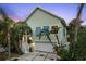 Charming home exterior with a two-car garage, tropical landscaping, and a well-lit front porch at 3110 John Anderson Dr, Ormond Beach, FL 32176