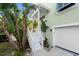 Welcoming front entrance with white stairs, lush landscaping, and a two-car garage at 3110 John Anderson Dr, Ormond Beach, FL 32176