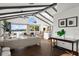 Spacious living room with exposed beams, wood floors, waterfront view and modern furnishings at 3110 John Anderson Dr, Ormond Beach, FL 32176