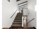 Bright stairway with modern railing that leads to the upper level and features beautiful wood floors on the lower level at 3110 John Anderson Dr, Ormond Beach, FL 32176