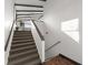 Bright stairway with dark railing that leads to the upper level featuring wood floors on the lower level at 3110 John Anderson Dr, Ormond Beach, FL 32176