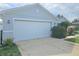 A large two car garage with a concrete drive and manicured bushes at 3339 Croton Ave, Deltona, FL 32738
