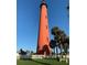 Scenic view of the lighthouse, standing tall against a clear blue sky, surrounded by lush greenery and a white picket fence at 3339 Croton Ave, Deltona, FL 32738