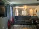Cozy living room showcasing a leather sofa, modern curtains, and open access to game room at 3339 Croton Ave, Deltona, FL 32738