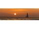 Picturesque ocean view featuring a sailboat silhouetted against a stunning sunset, creating a tranquil and serene scene at 3339 Croton Ave, Deltona, FL 32738