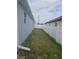 Narrow side yard with grass and a white vinyl fence provides privacy at 3339 Croton Ave, Deltona, FL 32738
