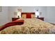 Comfortable bedroom showcasing a floral-patterned duvet, red pillows, and classic cherry wood nightstands at 3988 Radley Ct, Longwood, FL 32779