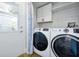 Functional laundry room with modern washer and dryer, plus cabinet storage and backyard access at 3988 Radley Ct, Longwood, FL 32779