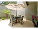 Outdoor patio featuring an umbrella-covered dining table, chairs, and a view of lush greenery at 3988 Radley Ct, Longwood, FL 32779
