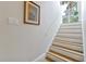 Bright staircase featuring wood treads and white risers, complemented by fresh white walls and natural light at 3988 Radley Ct, Longwood, FL 32779