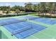 Overhead view of vibrant blue and green tennis courts in a well-maintained community at 3988 Radley Ct, Longwood, FL 32779
