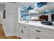 Elegant wet bar featuring white cabinets, modern countertops, ample storage and a mirrored backdrop creating a luxurious and functional space at 3988 Radley Ct, Longwood, FL 32779