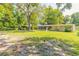 Large backyard features lush greenery, mature trees, and a screened-in porch, creating an idyllic outdoor haven at 442 Dorothy Ave, Daytona Beach, FL 32117