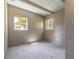 Neutral bedroom features ample natural light from two windows and soft carpeting, offering a tranquil and versatile space at 442 Dorothy Ave, Daytona Beach, FL 32117