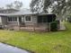 Inviting townhouse featuring a covered porch and a well-maintained, green lawn at 79 Cypress Pond Rd # 79, Port Orange, FL 32128