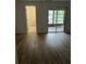 Bright living room featuring wood flooring, neutral wall paint and entrance to bathroom and outdoor patio at 79 Cypress Pond Rd # 79, Port Orange, FL 32128