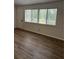 Bright living room featuring wood flooring, a large window with blinds, and neutral wall paint at 79 Cypress Pond Rd # 79, Port Orange, FL 32128