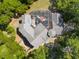 Aerial view of a large home with a screened pool, patio area, and lush surrounding trees at 4920 Sw 78Th Ave, Bushnell, FL 33513