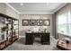 Bright home office with a large desk, built-in shelving, and comfortable seating at 746 Copper Creek Dr, New Smyrna Beach, FL 32168