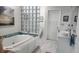 Bright bathroom with a soaking tub, blue glass blocks and white vanity sink at 2719 Brookline Ave, New Smyrna Beach, FL 32168