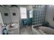 Bright bathroom featuring a soaking tub, glass block wall and a white vanity sink at 2719 Brookline Ave, New Smyrna Beach, FL 32168