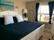 Cozy bedroom with beach-themed decor, ample natural light, and tile flooring at 2390 Ocean Shore Blvd # 1040, Ormond Beach, FL 32176