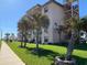 The exterior of the building features palm trees and well maintained lawn at 2390 Ocean Shore Blvd # 1040, Ormond Beach, FL 32176