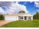 Single-story home with a white garage door and a manicured lawn at 2105 Aibonito Cir, Clermont, FL 34711