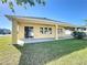 Backyard featuring a covered patio, large windows, grass, a privacy fence and well-maintained landscaping at 2588 Egret Loop, Kissimmee, FL 34743
