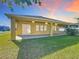 Backyard view featuring a covered patio, large windows, grass, a privacy fence and well-maintained landscaping at 2588 Egret Loop, Kissimmee, FL 34743