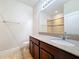 Bathroom featuring wood cabinets, granite countertops, large mirror, and tile flooring at 2588 Egret Loop, Kissimmee, FL 34743