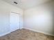 Empty bedroom with neutral walls, tile floors, and a closet at 2588 Egret Loop, Kissimmee, FL 34743