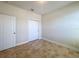 Neutral bedroom featuring closet, door, tan colored-tile floor, and neutral colored walls at 2588 Egret Loop, Kissimmee, FL 34743