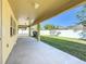 Covered patio overlooking the fenced backyard with lush green grass and plenty of room for entertaining at 2588 Egret Loop, Kissimmee, FL 34743