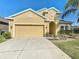 Charming single-Gathering home featuring a two-car garage, manicured lawn, and bright stucco exterior at 2588 Egret Loop, Kissimmee, FL 34743
