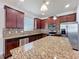 Modern kitchen featuring granite countertops, stainless steel appliances, and a center island at 2588 Egret Loop, Kissimmee, FL 34743