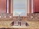 Close-up of a kitchen sink with granite countertops and a tile backsplash at 2588 Egret Loop, Kissimmee, FL 34743