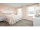 Charming bedroom with soft peach walls, large windows, and cozy bedding at 5043 Bear Lake Loop, Deland, FL 32724