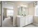 Bright bathroom with double sinks, white cabinets, and a shower visible through the doorway at 5047 Bear Lake Loop, Deland, FL 32724