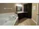 Spa-like bathroom with corner soaking tub and dark cabinetry at 629 Copeland Dr, Haines City, FL 33844